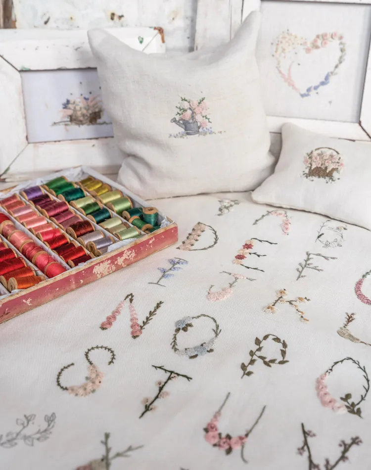 Beauty in Simplicity, The Stitchery. Embroidered alphabet displayed next to an array of rainbow thread.