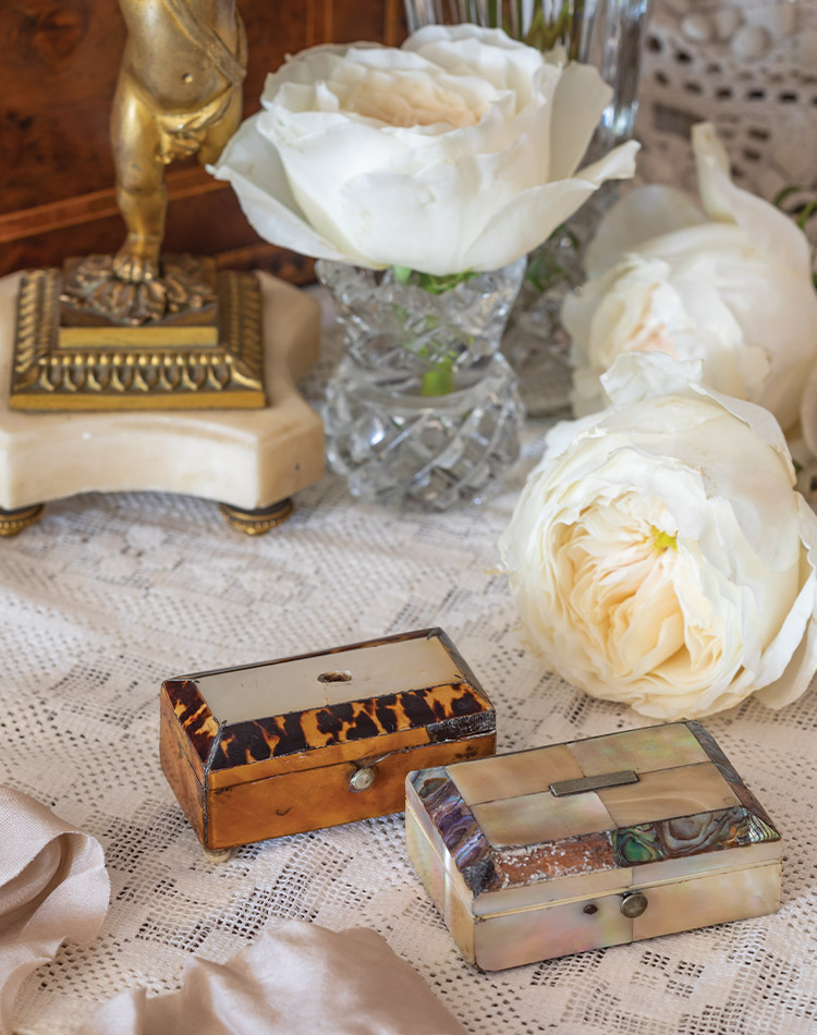 Billowing white blossoms are displayed behind a pair of small boxes inlaid with mother-of-pearl.