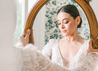 Wedded Bliss: 9 Ways to Add Romance to Your Wedding Events. A lovely bride clad in a delicate lace gown gazes into a gilt-edged mirror.