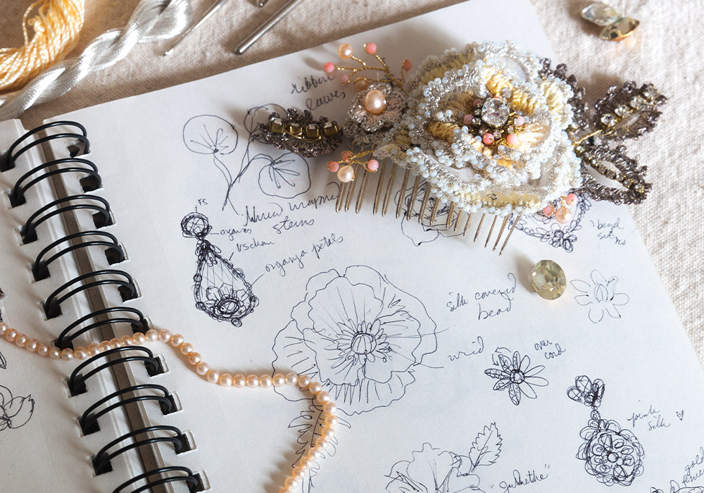 An array of pearls and sparkling baubles sits atop sketches outlining the plans for bespoke accessories.