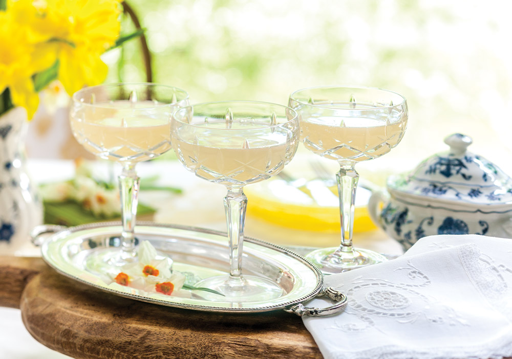 A trio of crystal champagne coupes sparkles with pale blond Elderflower Mimosas.