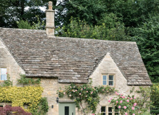 Preview Our Inviting English Cottage 2024 Special Issue: The walkway to the front door of this English cottage is lined with a profusion of flowers.