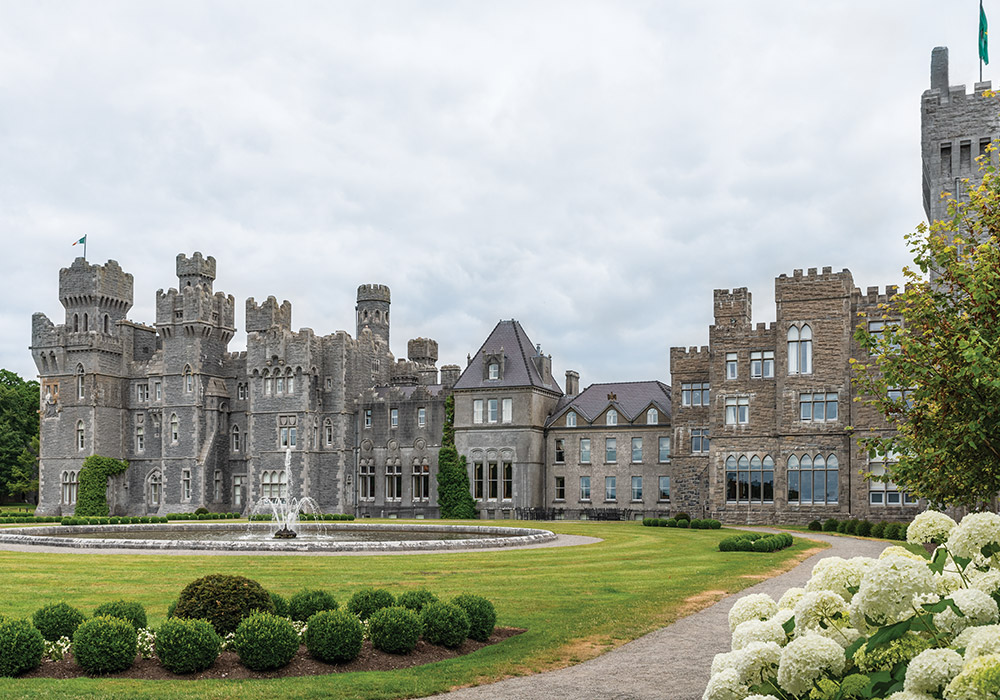 A picturesque fountain sets amidst the garden, overlooked by the gray weather-worn stones of Ashford Castle.