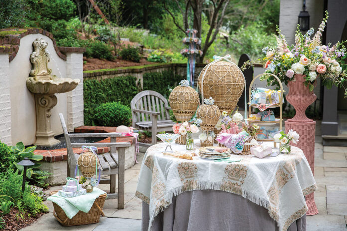 Here we offer an array of May Day ideas to revive pastoral fêtes. Set alongside a bubbling fountain in the ivy-laced cloister of a garden, a softly hued table is laden with spring blooms tucked into the basket of rattan hot air balloons, festive packages, and seasonal table settings.
