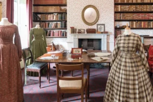 A display of gowns, books, and antiques in the Brontë Parsonage Museum