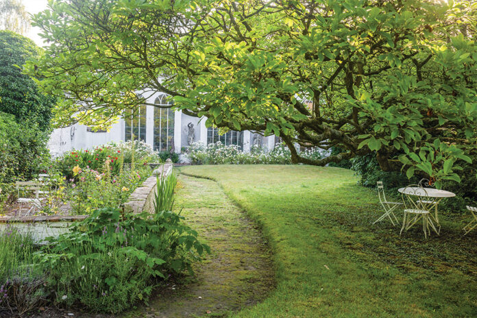 Pastoral greenery graces the property upon which this quaint abode rests.