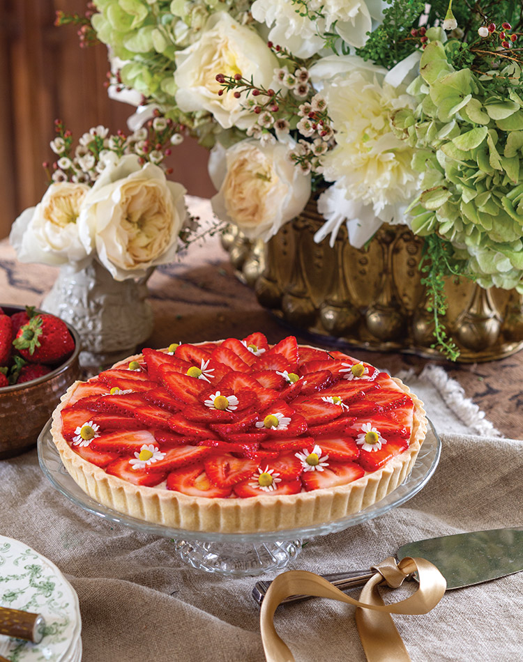 A few edible blooms top the sliced strawberries that fill Tartes aux Fraises.