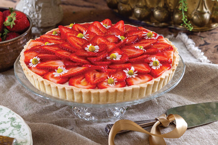 A few edible blooms top the sliced strawberries that fill Tartes aux Fraises.