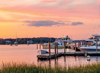 The sky turns a shade of salmon pink at sunset in this serene harbor.