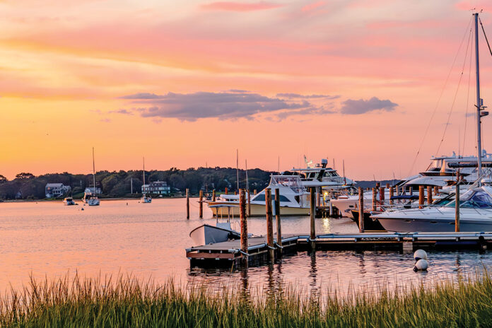 The sky turns a shade of salmon pink at sunset in this serene harbor.