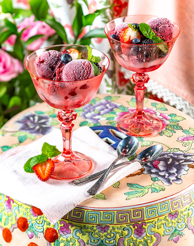 Bold pink chalices display our recipe for Summer Berry Rose Sorbet, brimming with strawberries, blueberries, and blackberries.