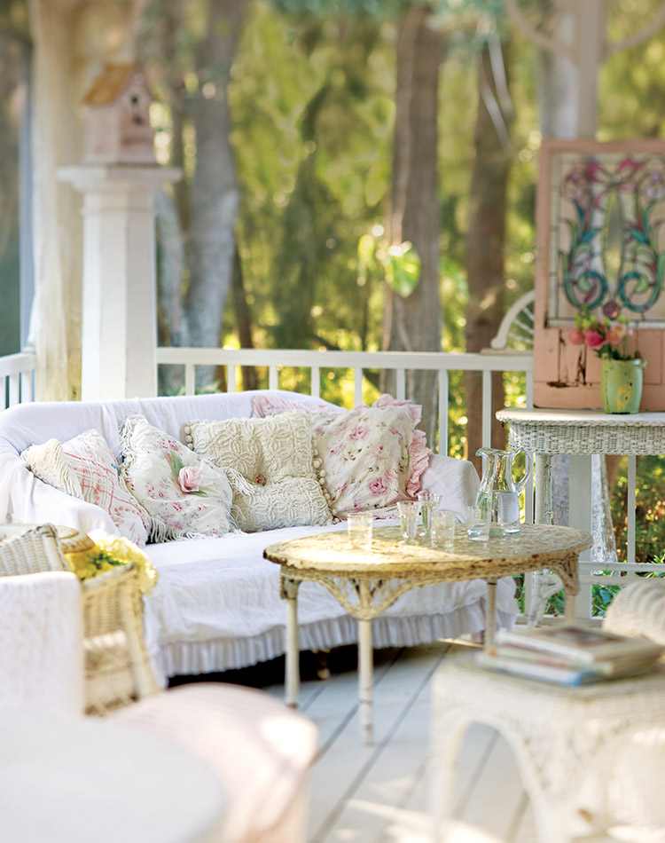 A sun-dappled porch with white couch sits waiting for an eager reader to enjoy their next chapter on a quiet afternoon.