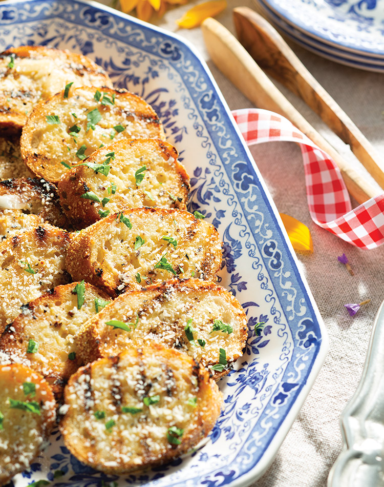 Slices of charred garlic bread arranged on a blue-and-white china platter.