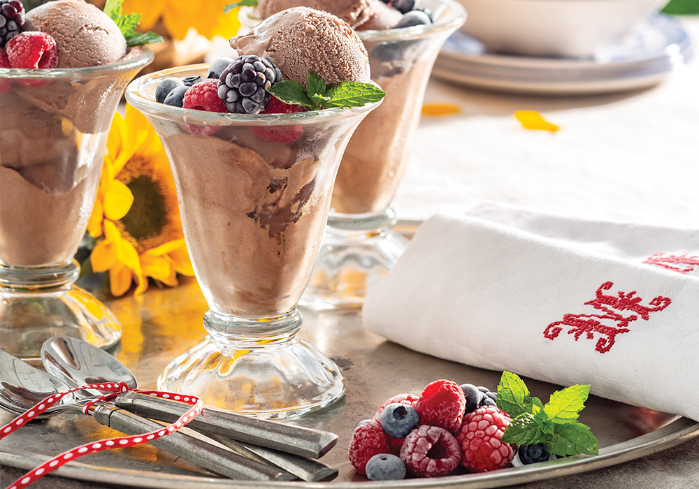 Dark Chocolate Custard Ice Cream in tall ice glasses, topped with frozen fresh berries.