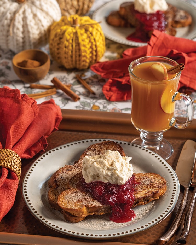 A serving of cinnamon French toast with cranberry compote and crème fraiche whipped cream brings autumnal charm to the breakfast table.