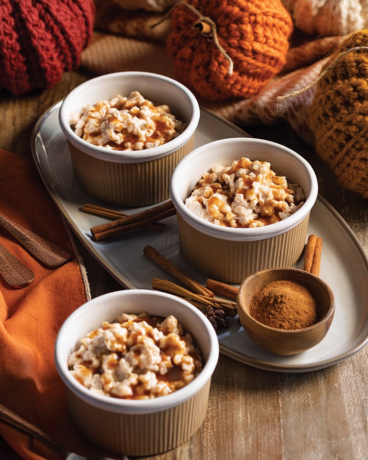 Sticks of cinnamon and a bowl of the spice are served beside deliciously creamy rice pudding.