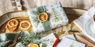 Victoria's Dogwood Hill wrapping paper adorning a gift accented with orange slices and greenery sprigs, with matching notecards.