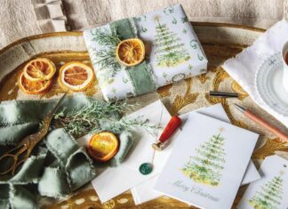Victoria's Dogwood Hill wrapping paper adorning a gift accented with orange slices and greenery sprigs, with matching notecards.