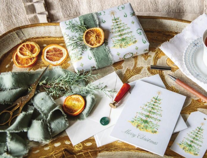 Victoria's Dogwood Hill wrapping paper adorning a gift accented with orange slices and greenery sprigs, with matching notecards.