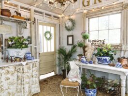 A garden shed adorned with blue-and-white chinoiserie pieces and winter greenery.