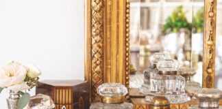 A collection of inkwells arranged in front of a mirror.