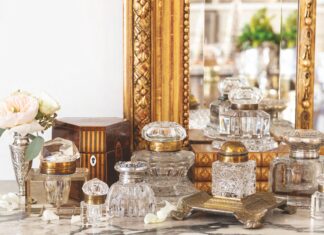 A collection of inkwells arranged in front of a mirror.