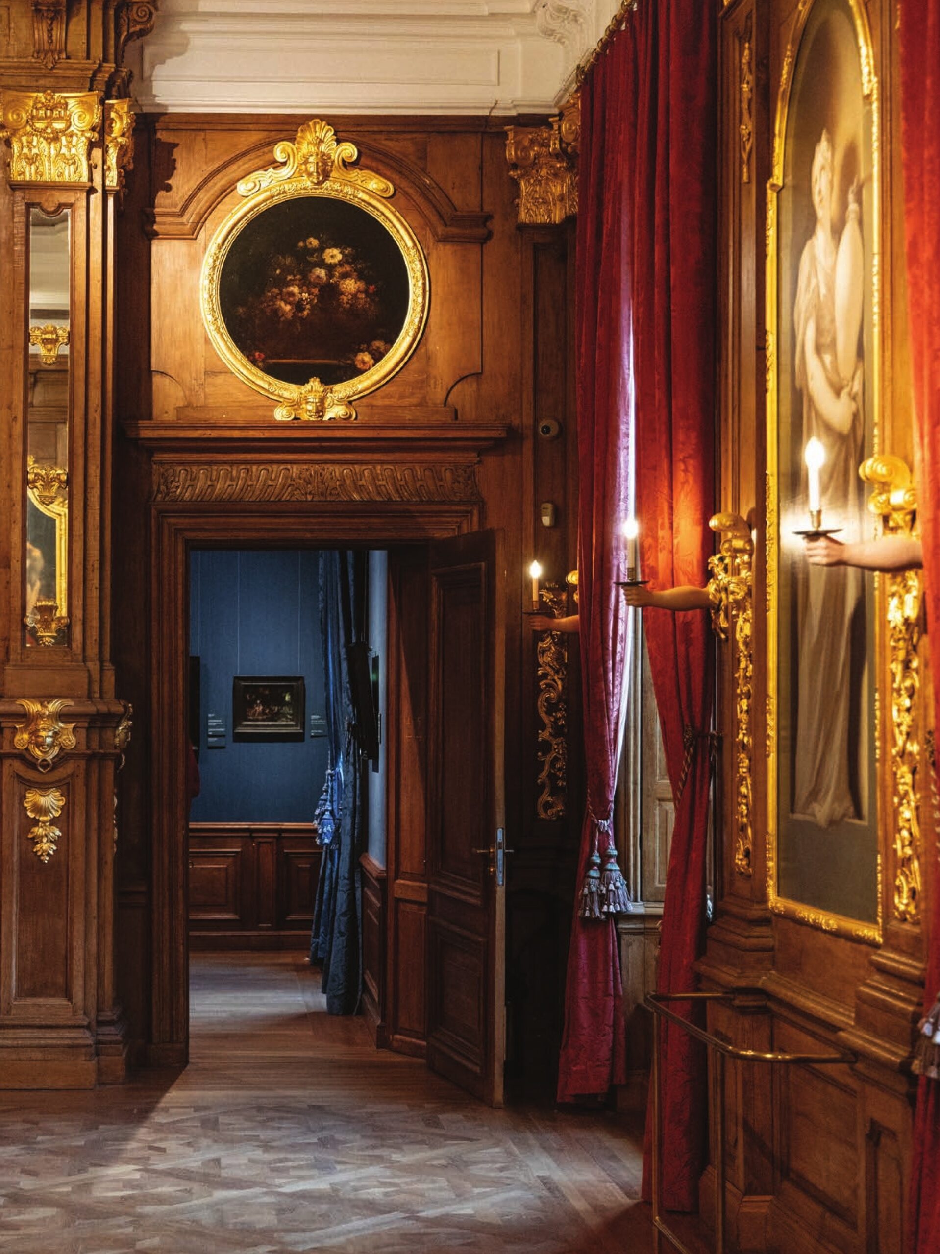 Opulent trimmings and moody surroundings in the Royal Picture Gallery in Amsterdam, adorned with ornate woodwork, oil paintings, and lush textiles.