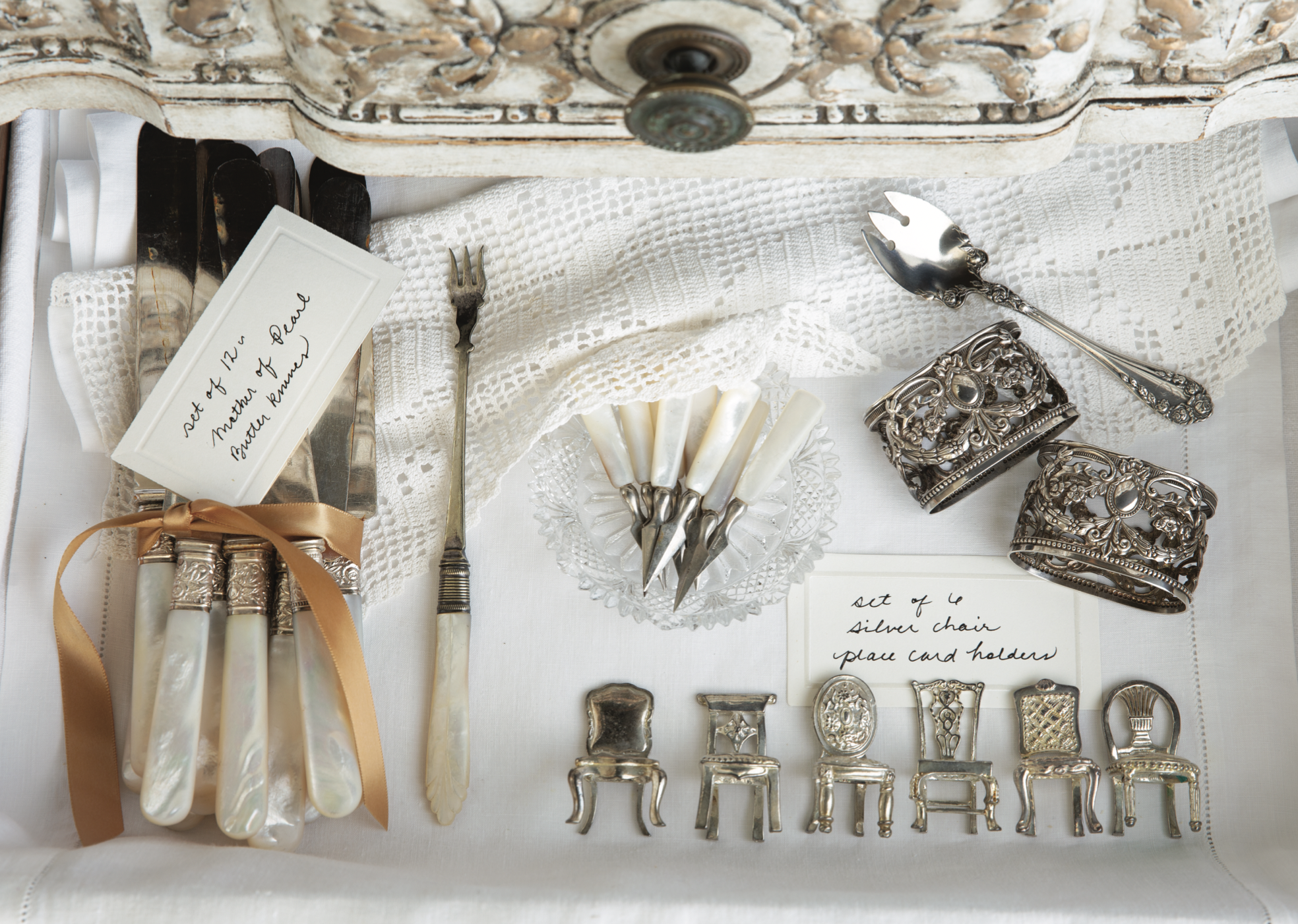 Antique silverware, place card holders, and napkin rings.