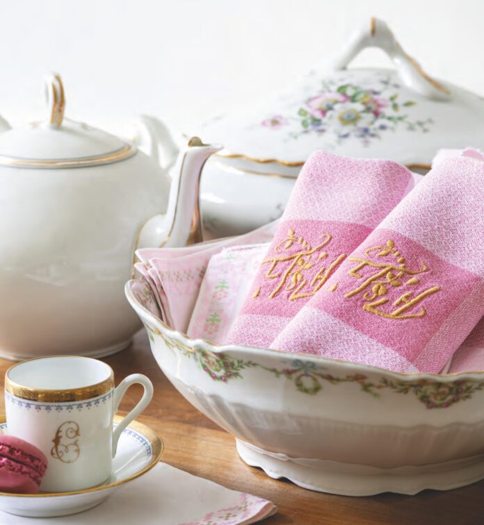 Pink embroidered linen napkins with a tea set.