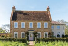 The English country house exterior of Ashbrook, surrounded by gardens.
