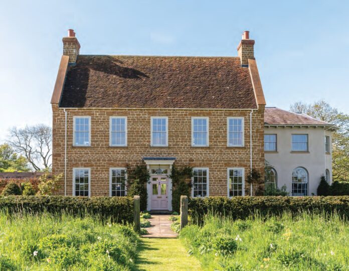 The English country house exterior of Ashbrook, surrounded by gardens.