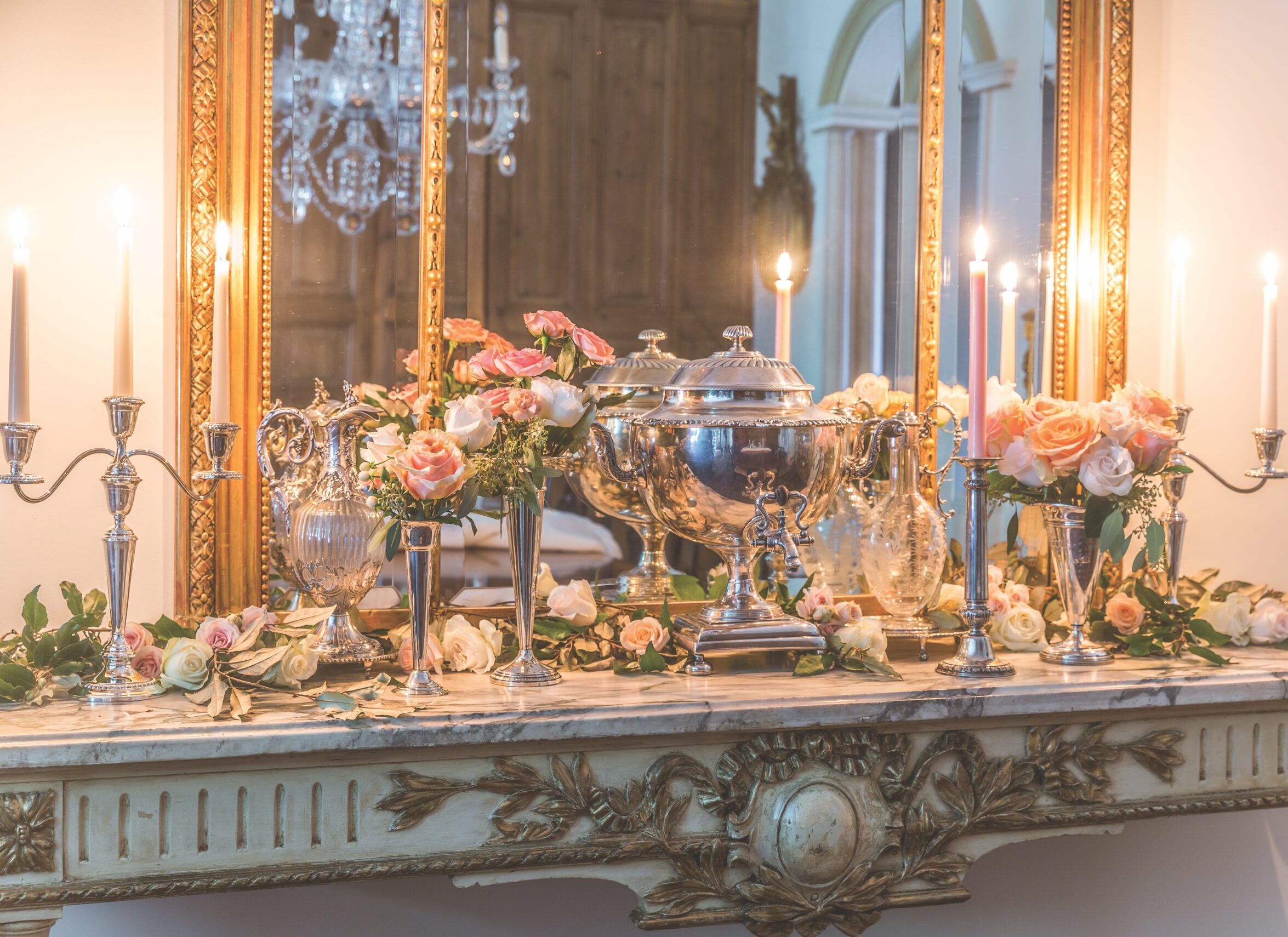 Winter flowers arranged on a sideboard with taper candles.