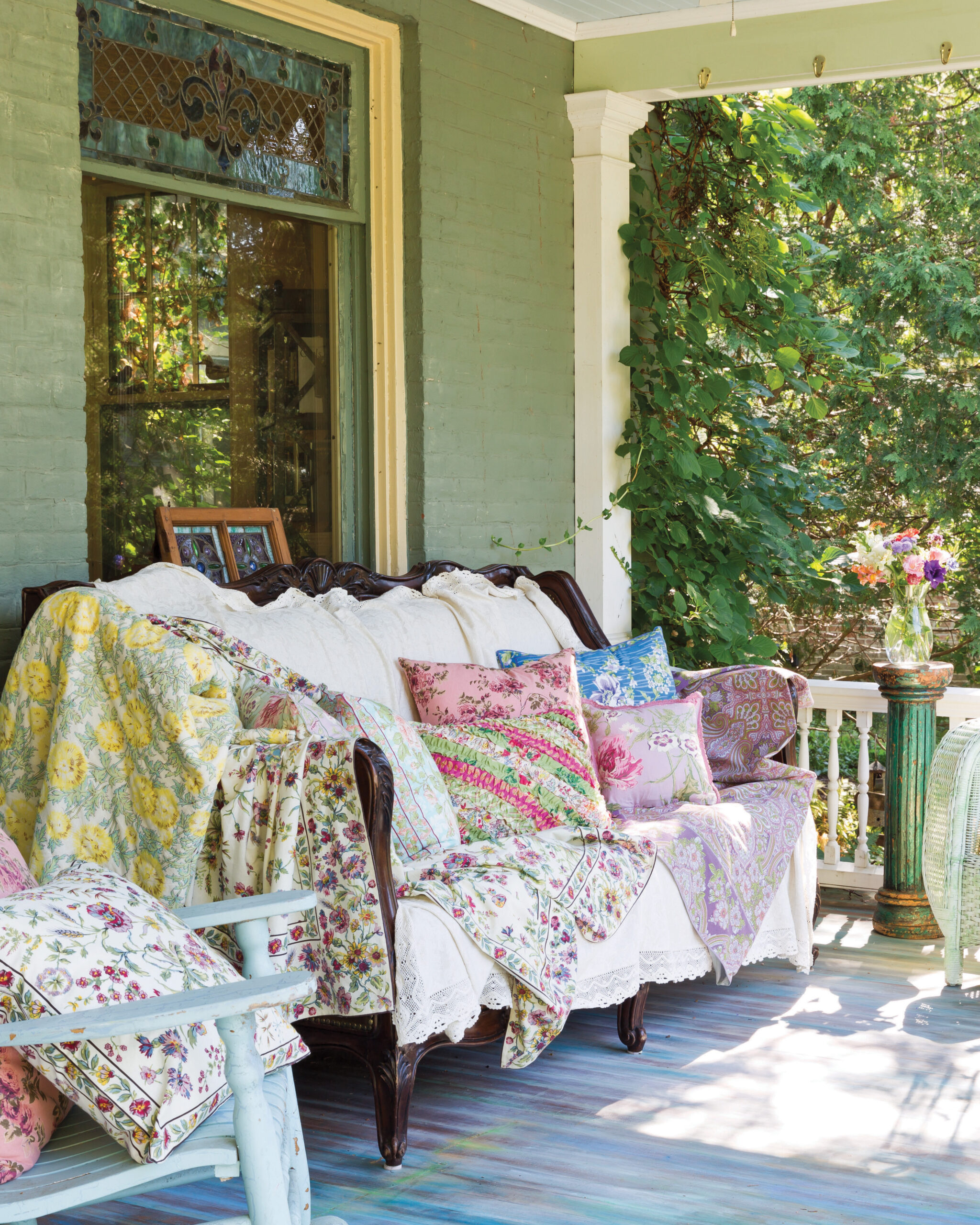 Quilts draped on couch on porch 