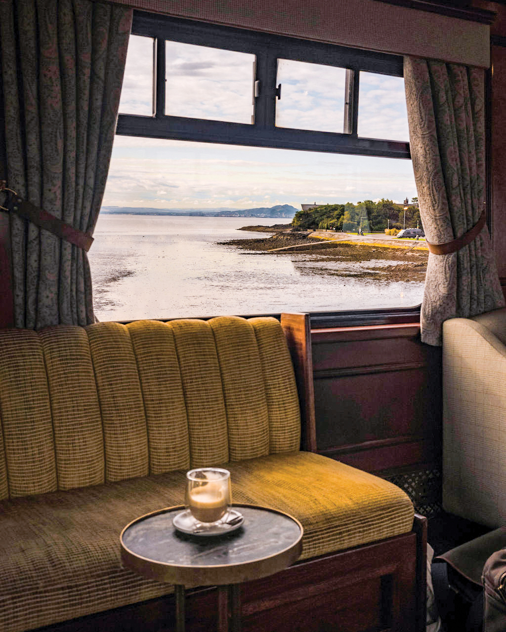 Seat on Royal Scotsman next to a window overlooking the coast