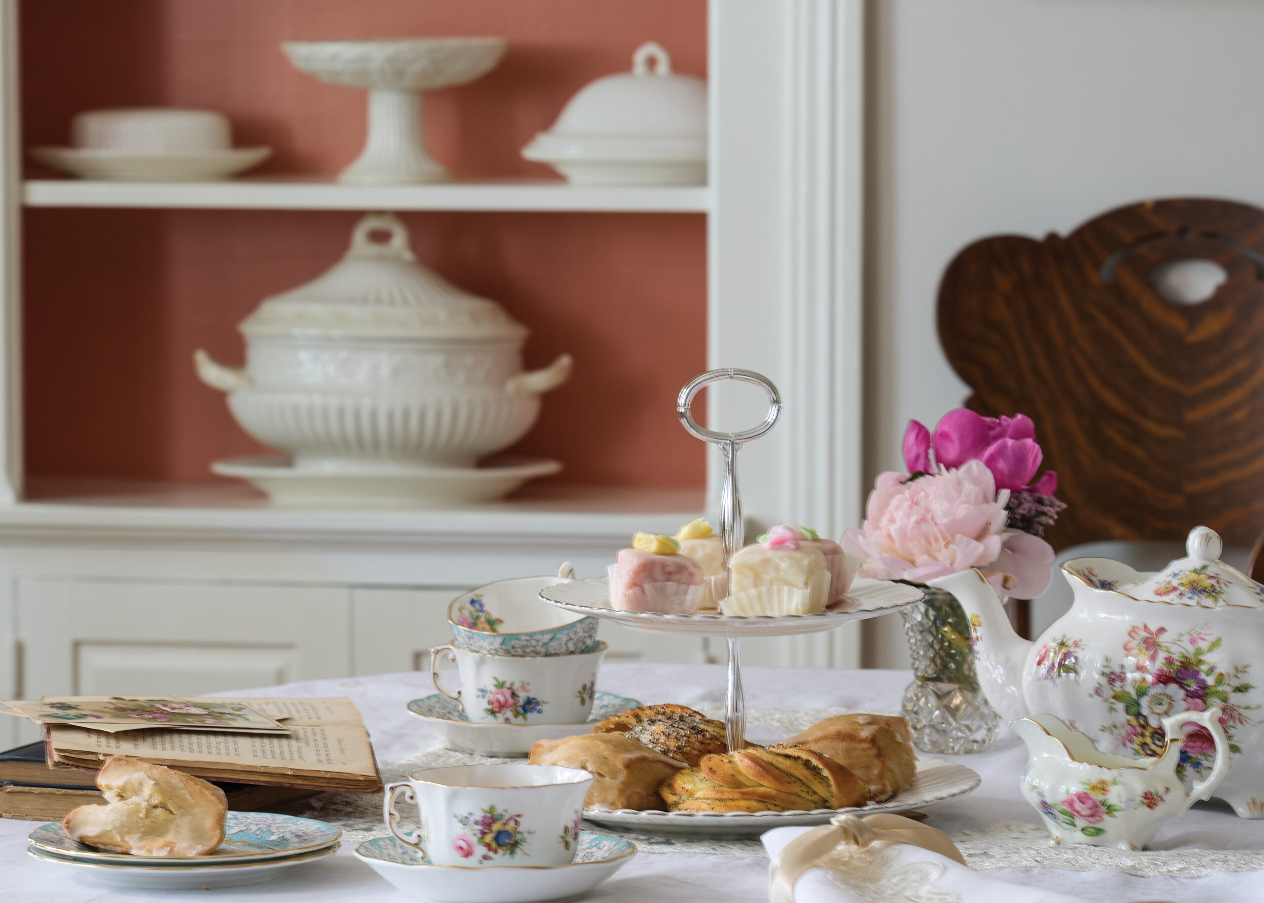 Tea cups and tea pot with pastries on a table