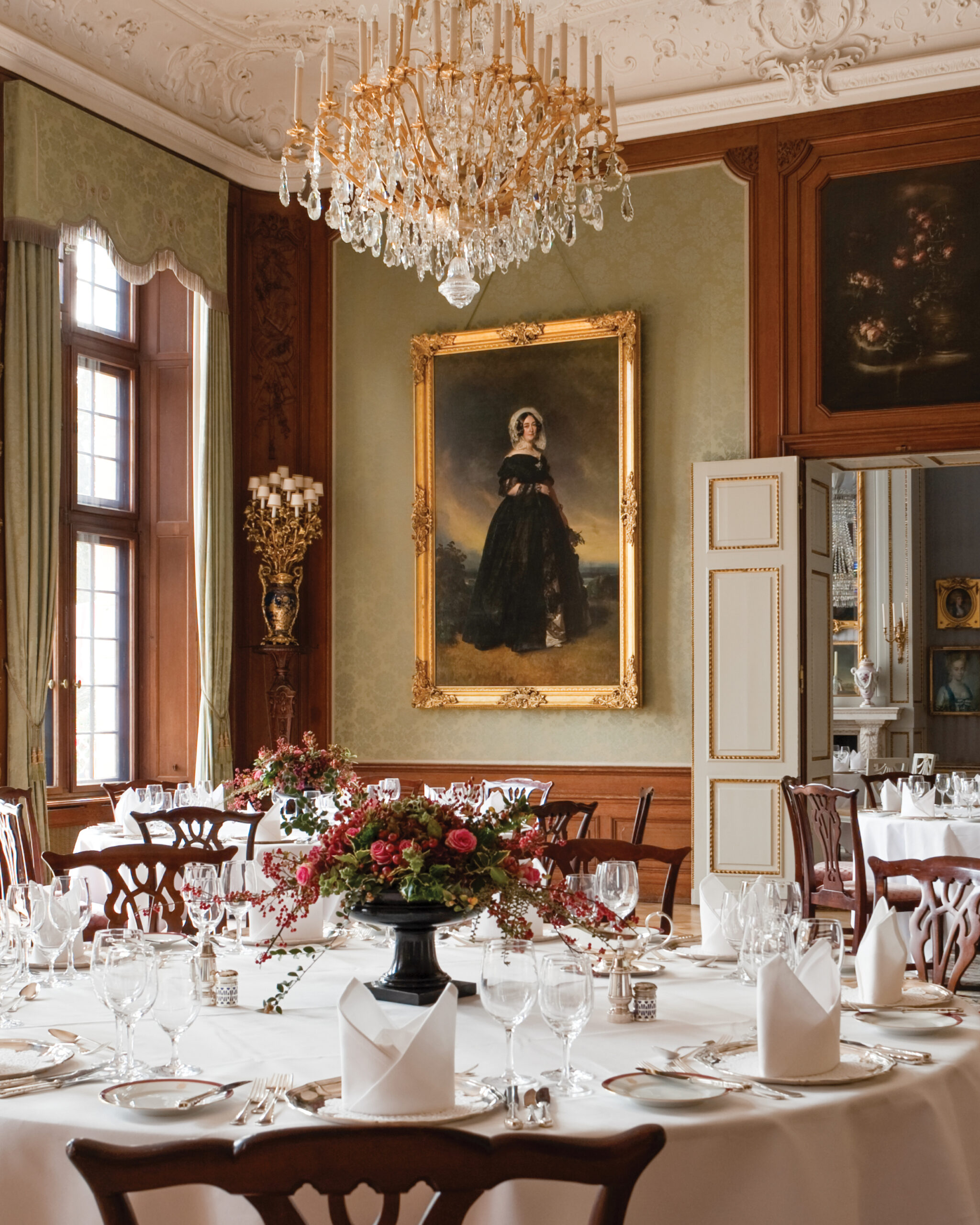 Fancy dining table with painted portrait of a queen in the background