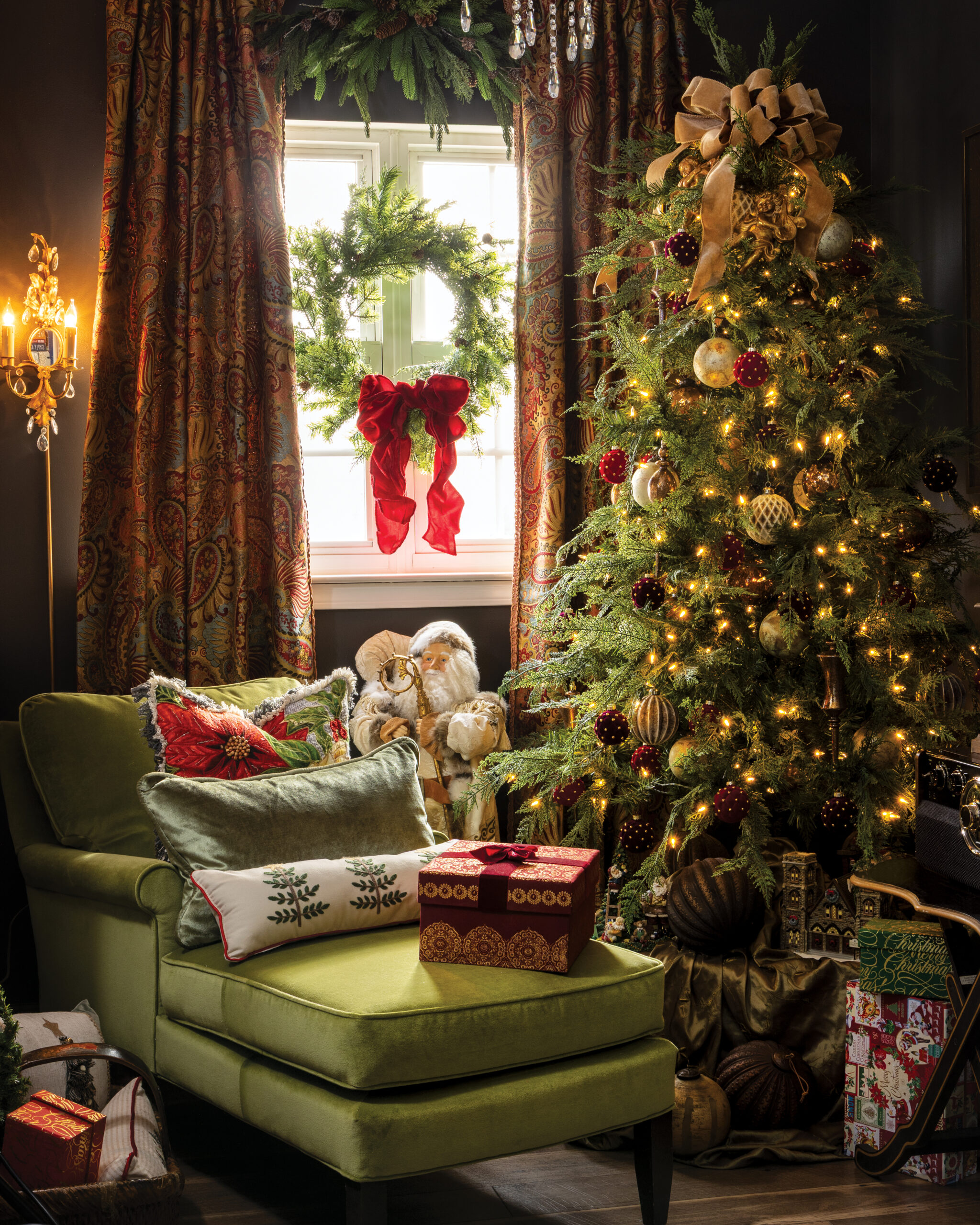 Green chair with Christmas pillows next to Christmas tree