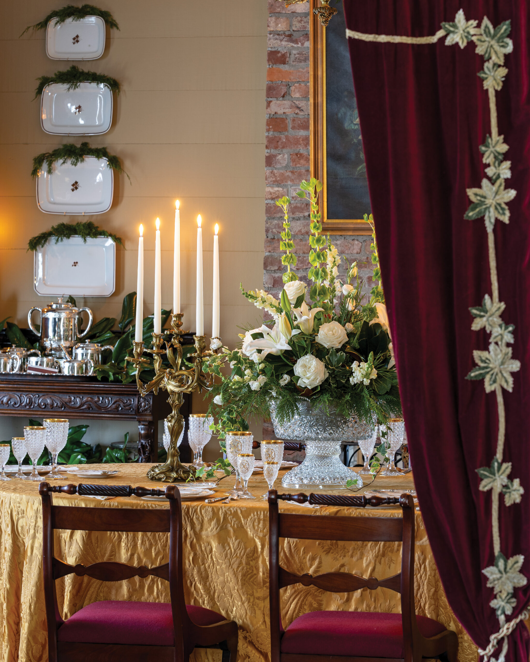 Velvet curtain revealing ornate dining room table setting