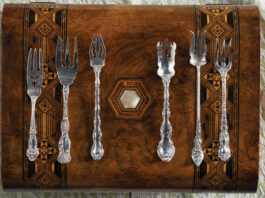 Silver collectibles on a wooden display case