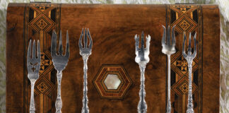 Silver collectibles on a wooden display case