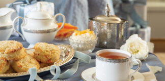 Citrus scones topped with clotted cream next to teacup