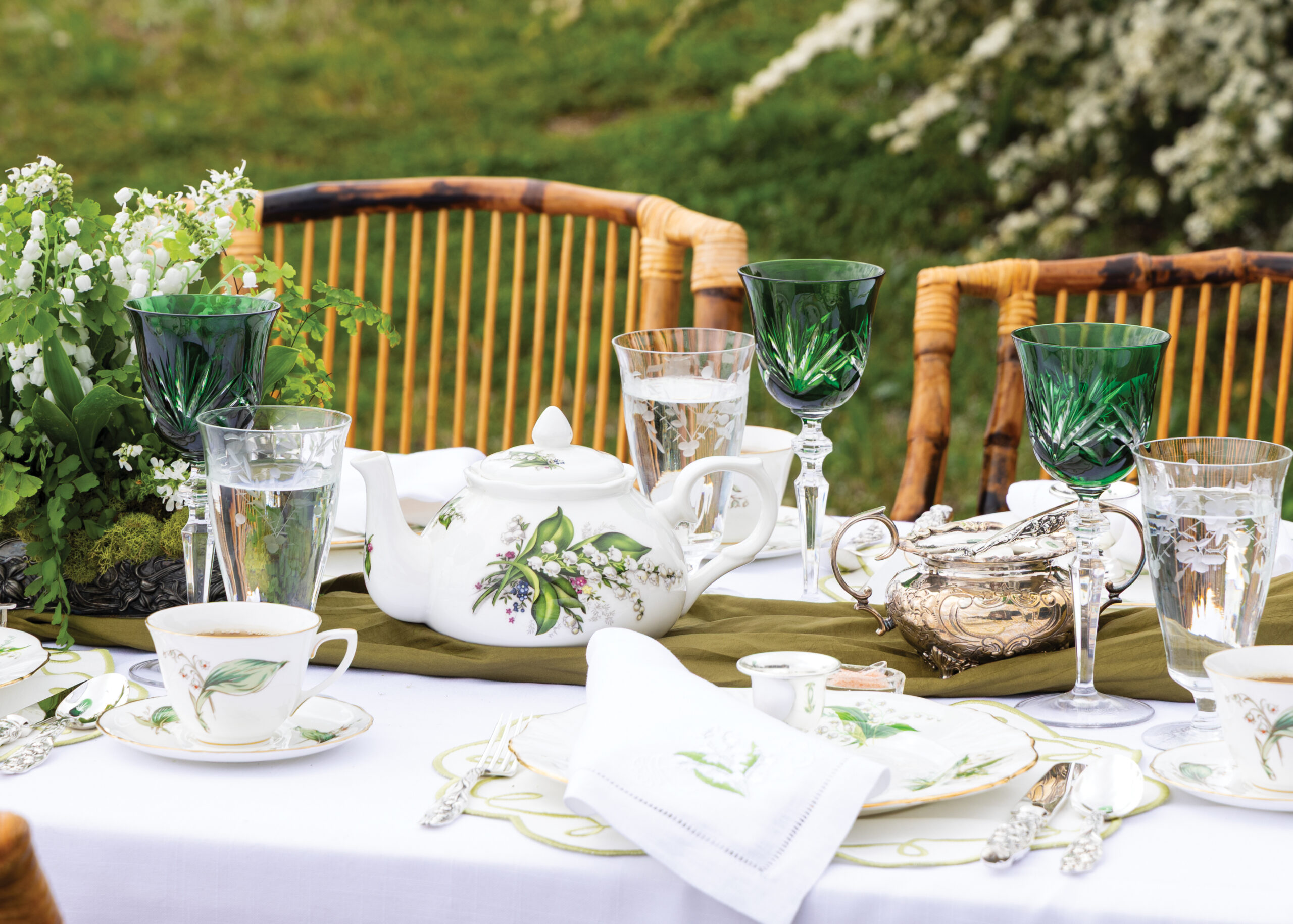 Tea party setup on table with lily of the valley theme
