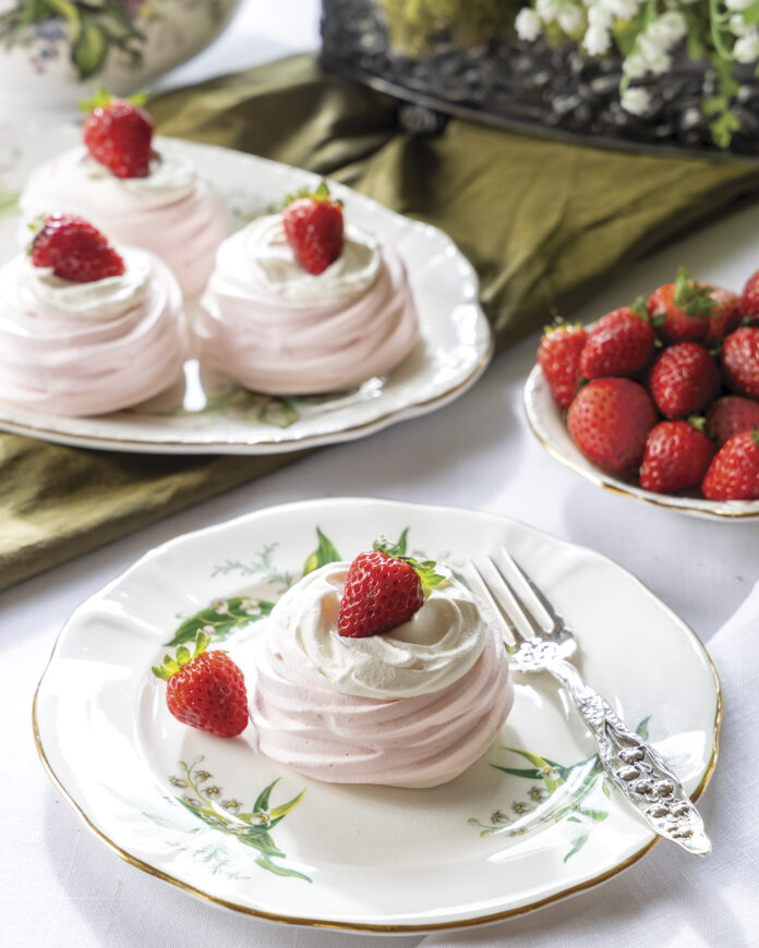 Blushing and dainty Mini Pavlovas hold lemon curd, whipped cream, and fresh berries.