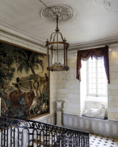 web_1 - Victoria view down a staircase with a tapestry on one all and a statue in a window seat