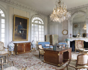 web_5 - Victoria elegant office with large wood desk and arched windows and chandelier and oil paintings on the walls